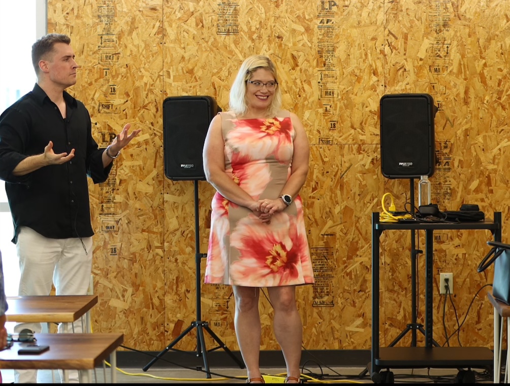 Joseph coaching a speaker in front of an audience